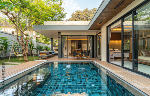 Small private pool villa in Phuket, tropical style with greenery and palm trees around the house © Kien