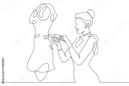 One continuous line.A fashion designer designs a dress. A seamstress works with a mannequin.Fashion designer, dressmaker, seamstress, sewing workshop or courses, tailoring concept. Continuous line dra