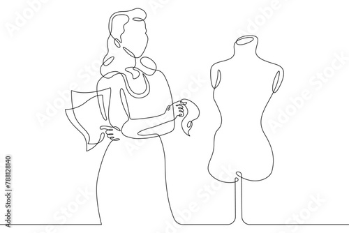 One continuous line.A fashion designer designs a dress. A seamstress works with a mannequin.Fashion designer, dressmaker, seamstress, sewing workshop or courses, tailoring concept. Continuous line dra