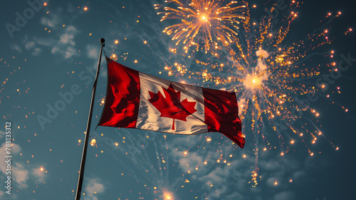 A Canadian flag flutters brightly against a clear blue sky surrounded by sparkling Victoria Day fireworks  photo