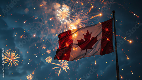 A Canadian flag flutters brightly against a clear blue sky surrounded by sparkling Victoria Day fireworks  photo
