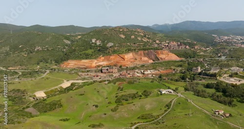 Aerial view of the former Monteponi mine, near Iglesias in Sardinia, Italy. The red color is due to the zinc and lead present in the soil. The mining plant is now closed. Mining concept. photo