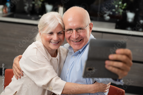Smiling senior couple taking selfie at home