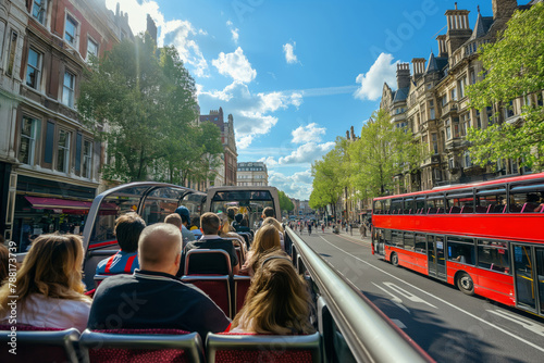 Group of tourists experiences a guided city tour aboard a double-decker open-top bus on a sunny day photo