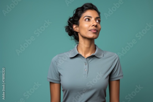 Portrait of a glad indian woman in her 30s wearing a breathable golf polo isolated in solid color backdrop © Markus Schröder