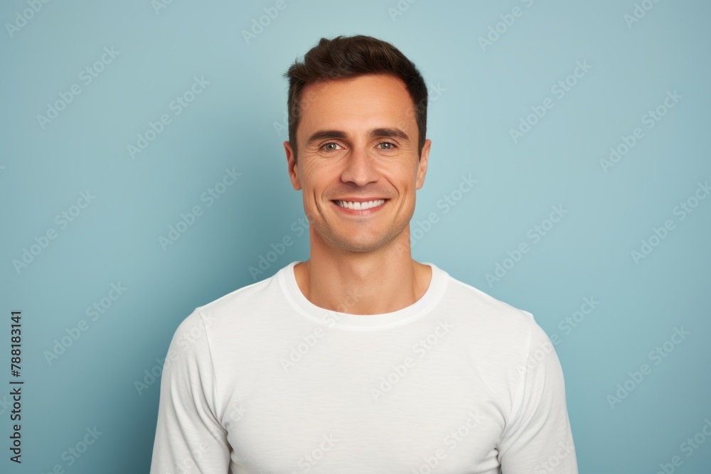 Portrait of a cheerful man in his 30s sporting a long-sleeved thermal undershirt over solid color backdrop