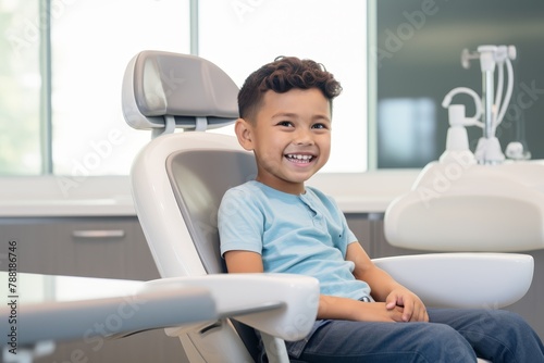 A boy sits in a dental chair at a dentist appointment and smiles