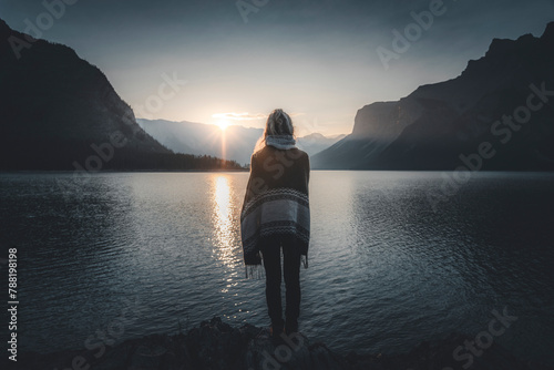 View of a person watching the sun rise over Lake Minnewanka, Alberta, Canada. photo
