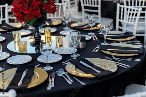 Obraz na płótnie Romantic garden wedding reception with round tables, gold accents, and red rose centerpieces w salonie