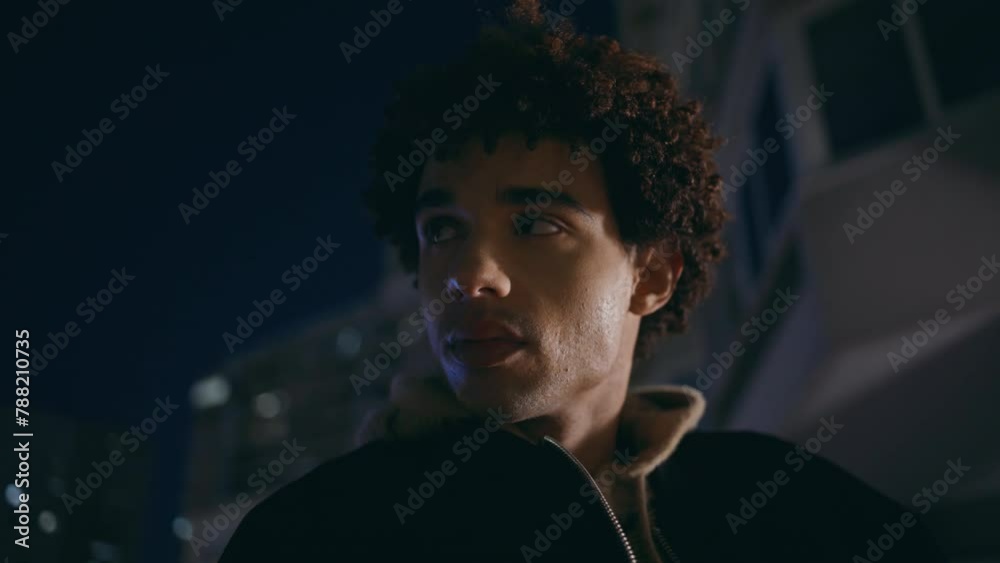 Portrait hispanic guy standing under city night sky. Man relaxing at dark town Portrait hispanic guy standing under city night sky. Man relaxing at dark town