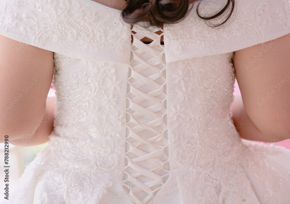 Tying the back of the bride's white evening dress - obrazy, fototapety, plakaty 