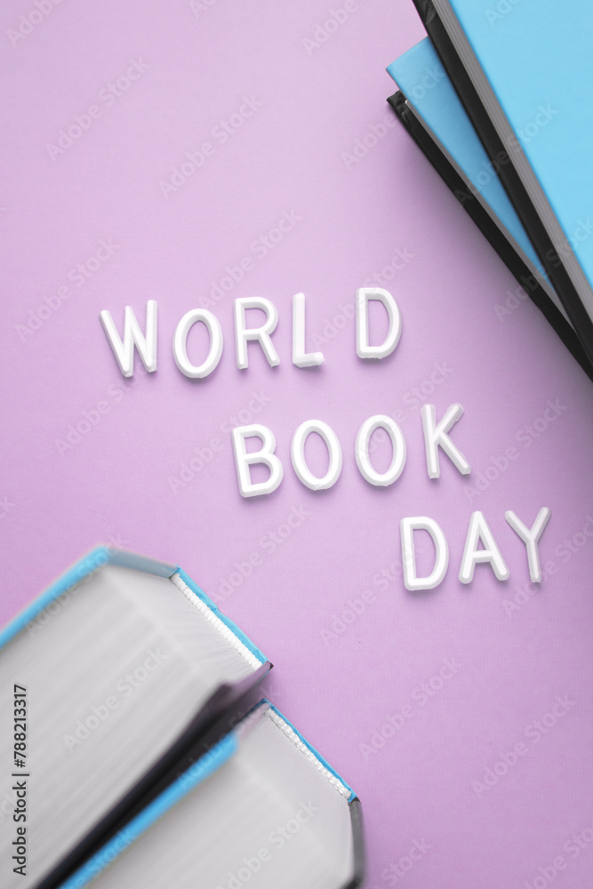 A stack of books in shades of electric blue, purple, and magenta with World Book Day written in violet font on the top book, all in a rectangular shape - obrazy, fototapety, plakaty 