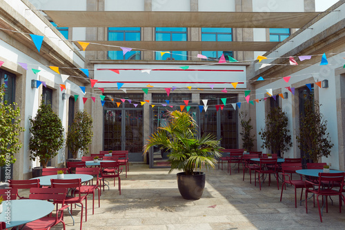 A courtyard, red chairs, and a large potted plant decorated for summer festival in June San Juan photo