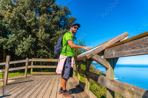 A tourist looking at an information panel at the Zumaia flysch in summer  Gipuzkoa. Basque Country