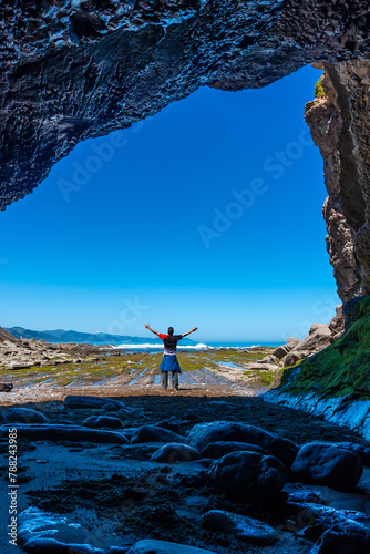 Man hiker in the Algorri cove sea cave on the flysch coast of Zumaia, Gipuzkoa. vertical photo