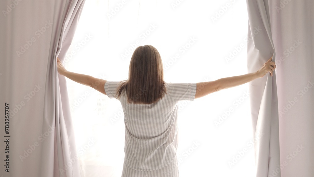 In serene atmosphere of morning, woman gracefully reveals day by opening curtains, inviting the soft glow of morning. With each gentle tug, room transforms, awakening to promise of a new morning. In serene atmosphere of morning, woman gracefully reveals day by opening curtains, inviting the soft glow of morning. With each gentle tug, room transforms, awakening to promise of a new morning.