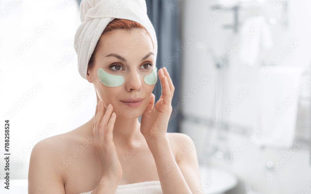 Woman wrapped in towel is examining her face in mirror, focusing on her skin, lips, eyebrows. She smiles at her reflection. Girl with towel on head takes care of her facial skin Woman wrapped in towel is examining her face in mirror, focusing on her skin, lips, eyebrows. She smiles at her reflection. Girl with towel on head takes care of her facial skin