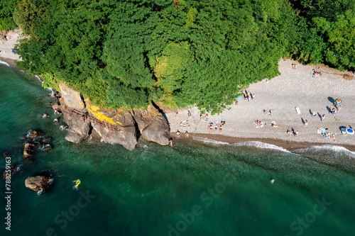 Aerial top view of Batumi beach lined with lush greenery and clear waters. 