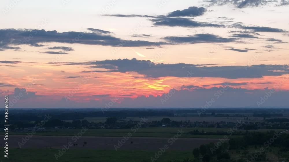 Aerial view of golden hour sunset with clouds, flying over agriculture land