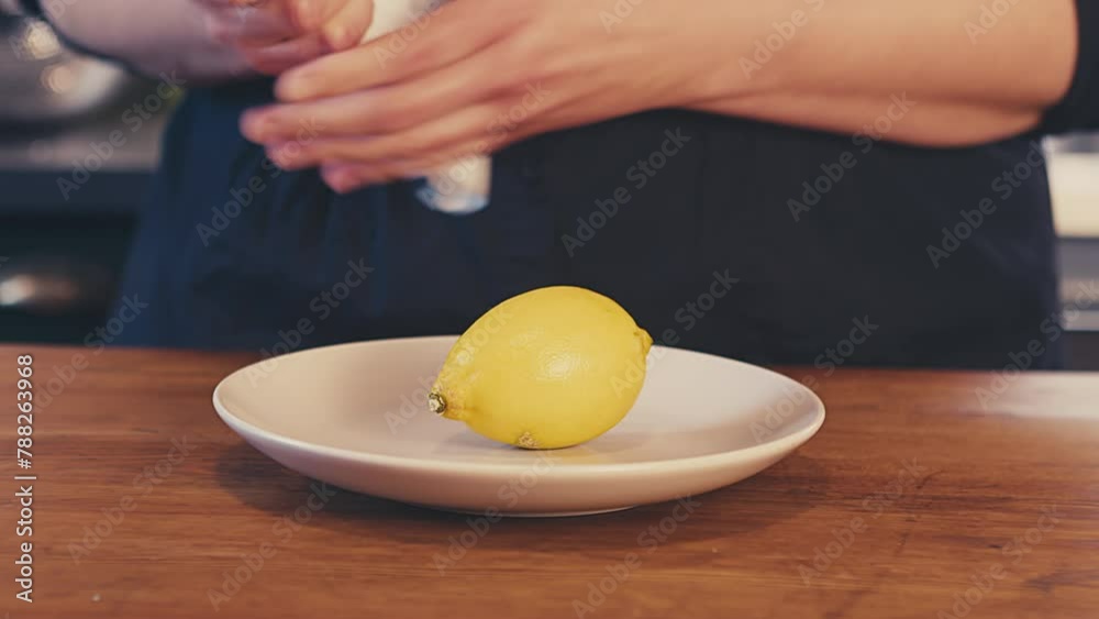 Close up of woman's hands cleaning, and wiping dry a whole fresh lemon with paper towel. Defocused brightly lit kitchen in the background. Studio shot. . High quality 4k footage Close up of woman's hands cleaning, and wiping dry a whole fresh lemon with paper towel. Defocused brightly lit kitchen in the background. Studio shot. . High quality 4k footage