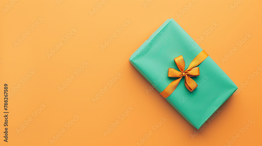 A green gift box with a yellow bow on an orange background. A green gift box with a yellow bow on an orange background.