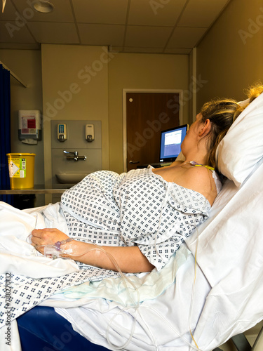 A woman in labour on her hospital bed at the delivery suite.