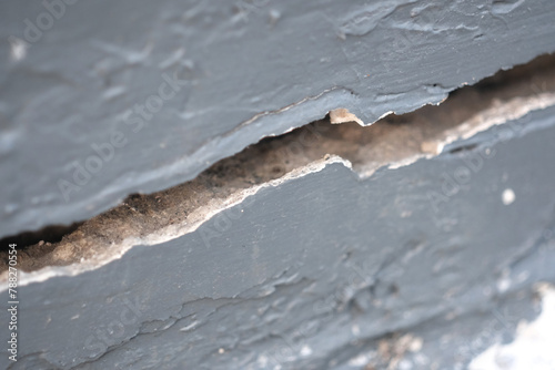 Large cracks in the gray cement wall, Close up view