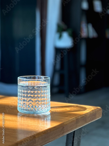Glass of clean mineral water on wooden table.