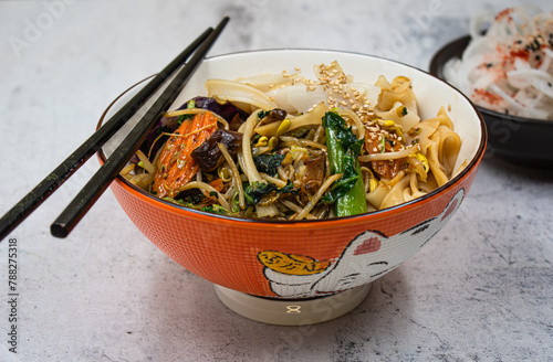 Vegan noodles and stir fry in asian bowl with chopsticks