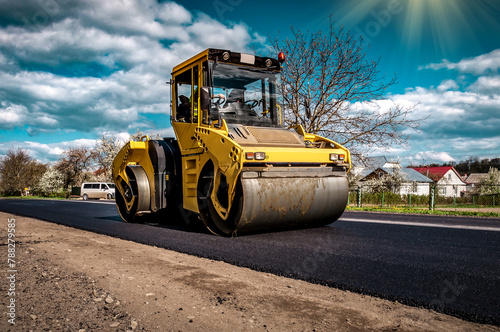 Road roller rolling new hot asphalt on the new road. Road construction.