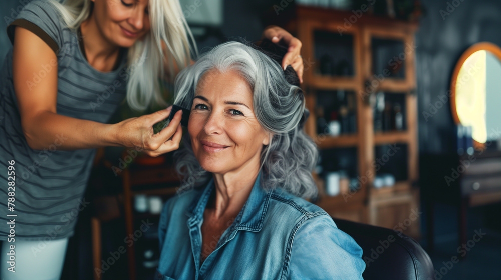 Hairdresser styling elderly woman's hair in a salon. Hairdresser styling elderly woman's hair in a salon.
