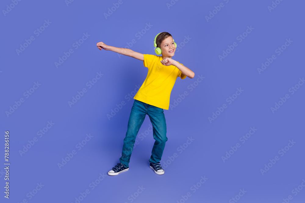 Photo of glad positive boy wear trendy yellow clothes have fun listen music look empty space isolated on purple color background Photo of glad positive boy wear trendy yellow clothes have fun listen music look empty space isolated on purple color background