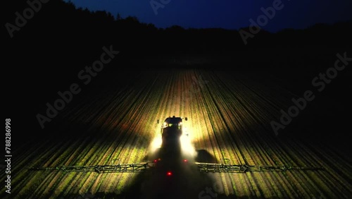 Night harvest, Aerial view captures the combine harvester working diligently, illuminating the fields, loading maize into trailers a vital scene in the agricultural supply chain (ID: 788286998)
