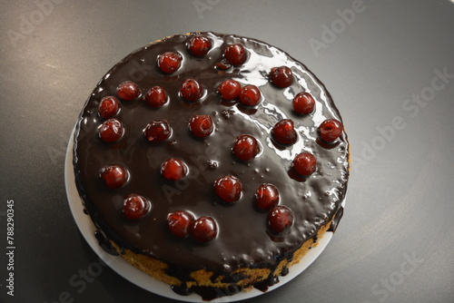 Food, Finnish cuisine, desserts. A very tasty sponge cake made with buttercream, chocolate frosting and red cherries.