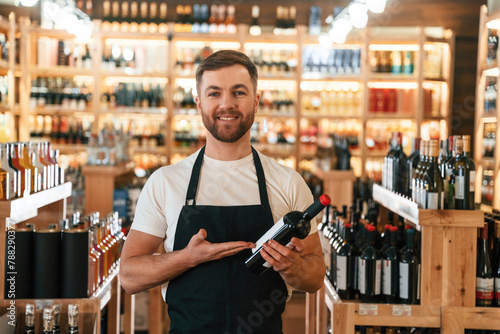 Positive man. Wine shop owner in white shirt and black apron