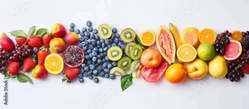 Fruits in a variety of colors arranged on a white background. Encouraging a healthy diet with ingredients for juices and smoothies. Room for text.