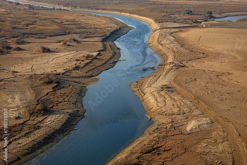 Aerial shot of a river nearly dry, its banks expanded and the bed mostly exposed. The drought’s impact on water levels is dramatical photo