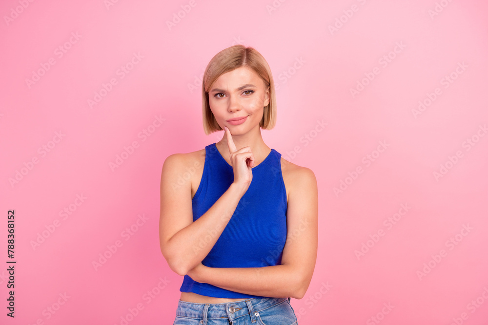 Photo of pretty young woman contemplate wear blue top isolated on pink color background Photo of pretty young woman contemplate wear blue top isolated on pink color background