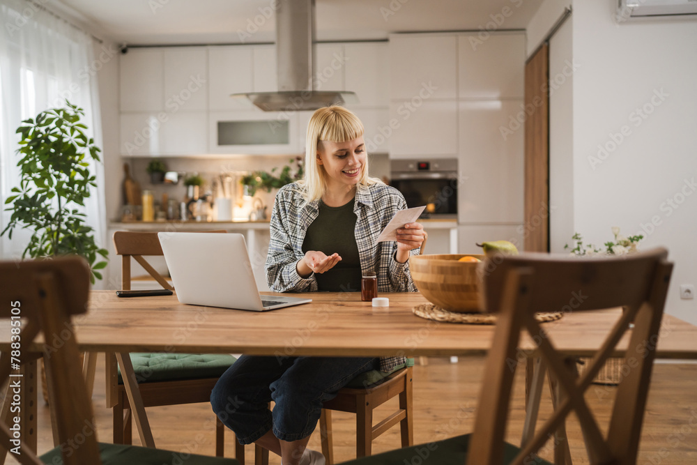 Young woman read instruction for medical browse internet at kitchen