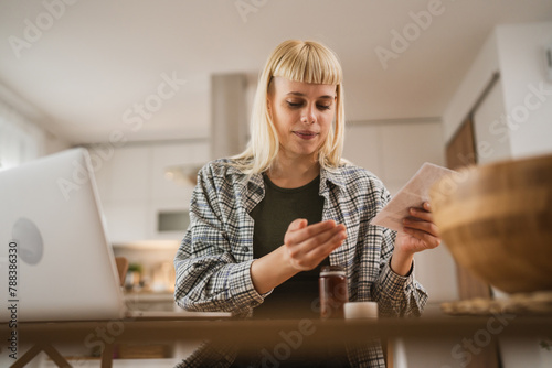 Young woman read instruction for medical browse internet at kitchen