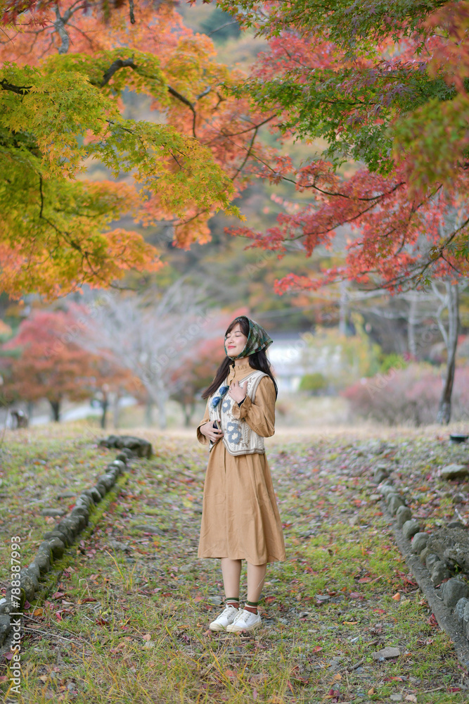 Asian woman in Japan's fall beauty, a cheerful holiday portrait amid yellow and red foliage. A journey capturing the essence of nature, fashion, and casual elegance. Asian woman in Japan's fall beauty, a cheerful holiday portrait amid yellow and red foliage. A journey capturing the essence of nature, fashion, and casual elegance.
