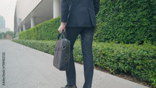 Mid Body shot of Business man walking and  along city walking path near glass office building and staircase, smart formal clothes urban commuter, business trading center, salesman going out for work