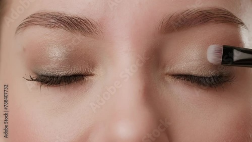 Close-up of female eyes with makeup in the process of applying eye shadow using a brush (ID: 788407732)