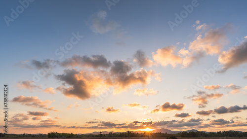 Sunset sky over hill countryside in the evening, Horizon sunny summer sky landscape with orange sunlight in golden hour background