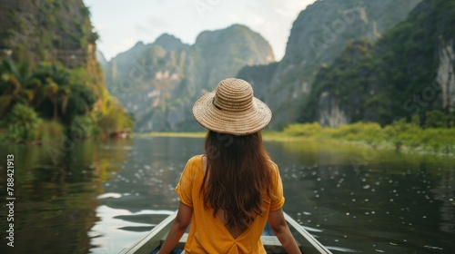 Young woman views Mountain View while sitting on a rowboat in Ninh Binh, Vietnam. © suteeda