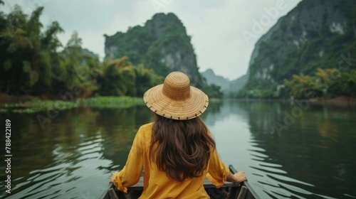 Young woman views Mountain View while sitting on a rowboat in Ninh Binh, Vietnam. © suteeda