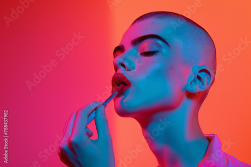 A male model with shaved hair is applying lipstick