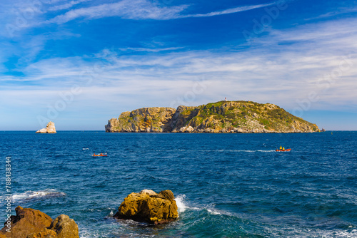 Kayakistas navegan las aguas azules frente a las Islas Medas cerca de Estartit, Cataluña, un escenario natural imponente bajo el cielo de primavera.