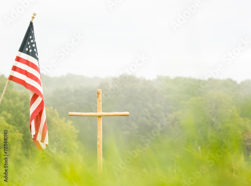 a cross and american flag in a field