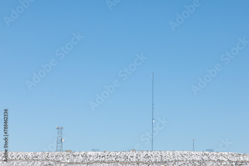 Communications towers and antenna on a hill in winter